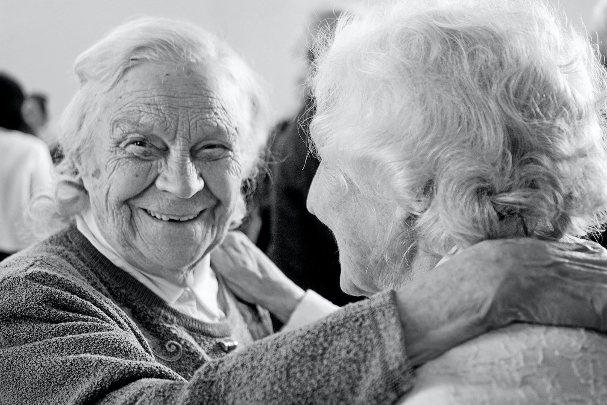 grayscale photo of woman in sweater smiling